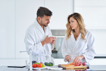 Happy couple cooking breakfast together in the kitchen