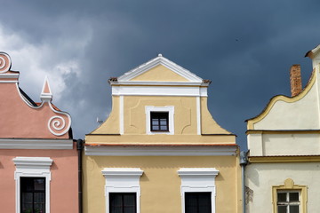 Colourful facade of old houses in Trebon, Czech republic. Dramatic sky at background.