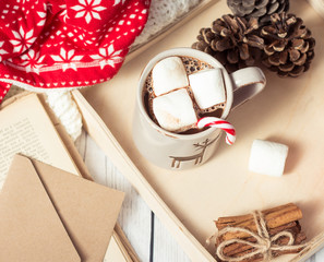 Christmas mood. Cozy Christmas breakfast. Plaid, a tray, a mug of hot cocoa, marshmallows. The book and Christmas card.