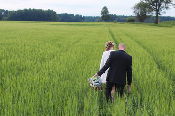 Couple lovers walking in field in summer day