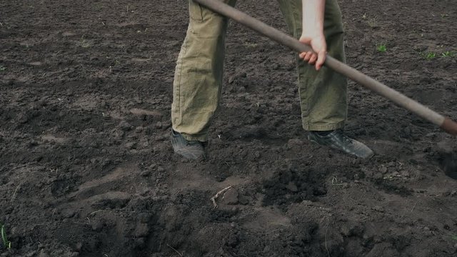 Man digging the ground with a spade on field
