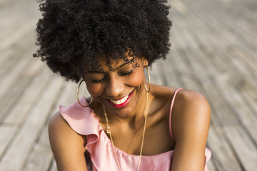 close up portrait of  a Happy young beautiful afro american woman sitting on wood floor and...