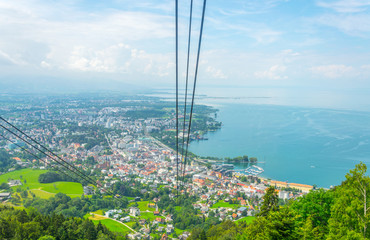View of a pfanderbahn cable car with the Austrian city Bregenz behind it.