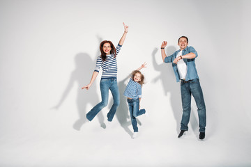 Fototapeta premium Happy family portrait jumping on white background isolated