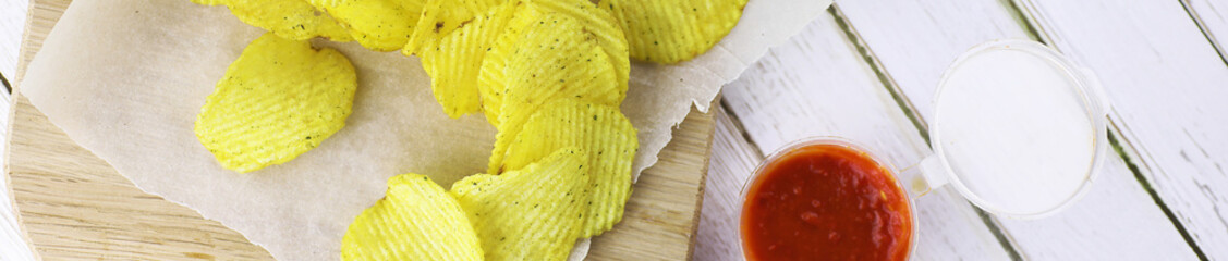 Horizontal bakground of potato chips on a table