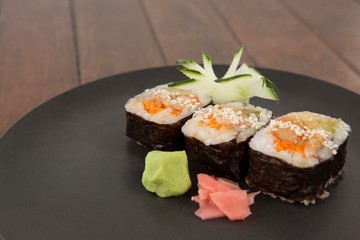 Three maki sushi served in black round plate