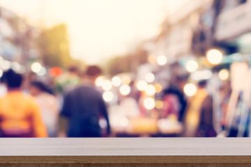wood table and display montage with Blurred people walking through a city street. vintage toned photo.