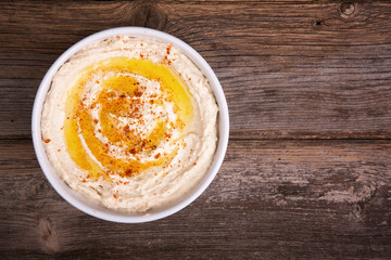 Bowl of hummus with olive oil and paprika - obrazy, fototapety, plakaty