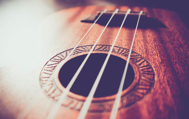 Ukulele guitar macro view, strings close up. Photo depicts musical instrument Ukulele small guitar...