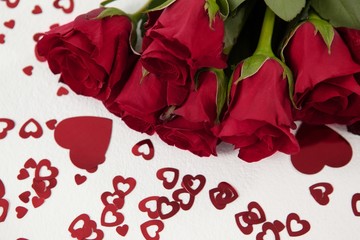 Bunch of red roses surrounded by heart-shaped decoration