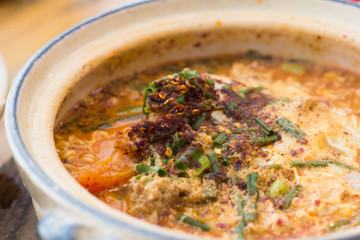 Tom Yum Kung with noodles and seafood, popular Thai food. Tom Yum Goong Spicy Sour Soup on wooden table top view, Thai local food