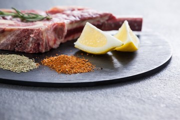 Blade chop, spices and lemon on black round tray