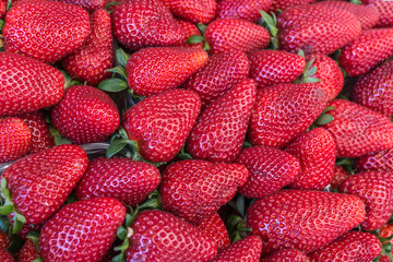 group of fresh ripe red vivid strawberries in summer market