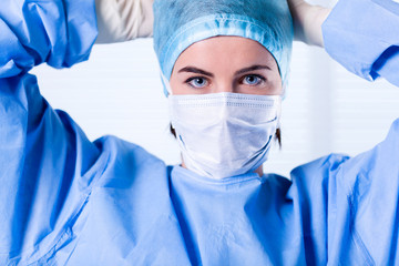 Female Surgeon wearing protective uniforms, cap and mask
