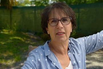Portrait of a mature brunette woman with eyeglasses, outdoor