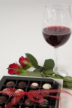 Bunch of roses, wine glass and assorted chocolate box
