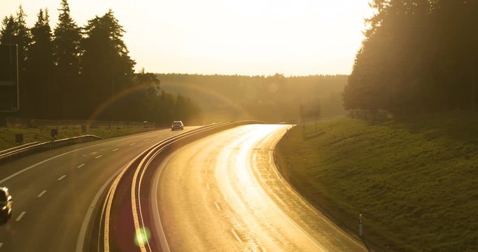 Cars And Trucks Driving On A Busy Highway At Sunset