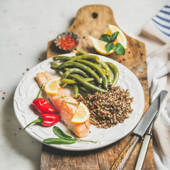 Healthy protein rich dinner plate. Oven roasted salmon fillet with multicolored quinoa, chilli pepper and poached green beans on rustic wooden board over grey marble background, square crop. Diet food