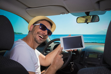 Man in car showing blank screen digital tablet device. Travel and technology concepts.