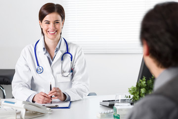 Smiling Young female doctor listening to patient