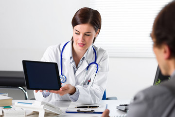 Doctor showing tablet to patient