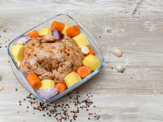 Chicken in marinade on a wooden table. 