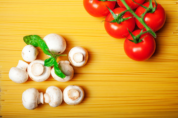 Italian dry pasta spaghetti with tomatoes and fresh herbs on a dark wooden background, selective focus