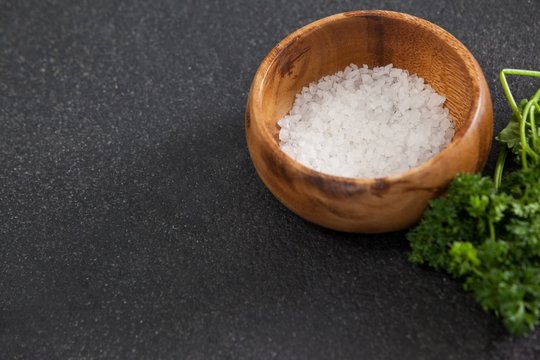Bowl of sea salt against black background