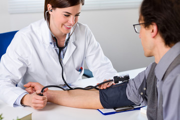 Female Doctor Checking Blood Pressure Of Patient