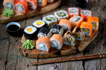 Homemade sushi with salmon, tobiko caviar, omelet, cucumber, sesame and soft cheese. Rustic style.