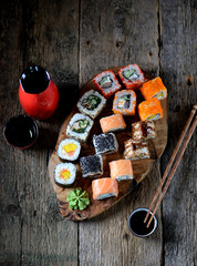 Homemade sushi with salmon, tobiko caviar, omelet, cucumber, sesame and soft cheese. Rustic style.