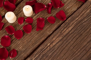 Wax candles surrounded with rose petals