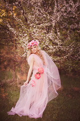 A young girl in floral wreath in nature