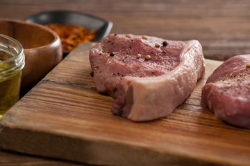 Sirloin chops on wooden board with ingredients