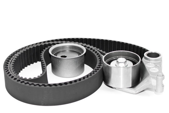 Spare parts for the ca r. Kit of timing belt with rollers on a light background.