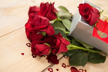 Bunch of roses and gift box surrounded by heart decoration