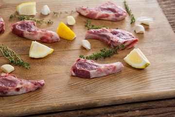 Ribs chops, lemon and garlic on wooden board