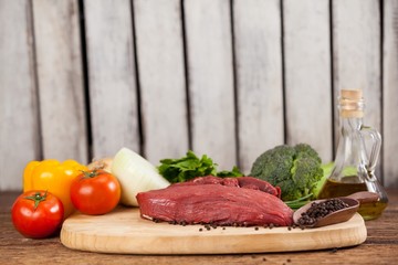 Beef steak on wooden board with ingredients