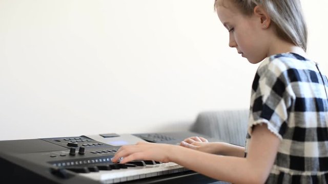 Little girl learning to play the piano.