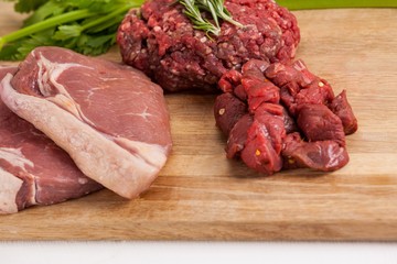 Sirloin chop, beef patty and diced beef on wooden board