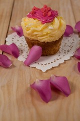 Rose petals place around muffin with heart shaped pink icing
