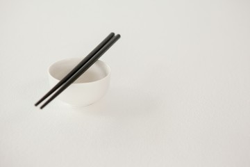 Pair of chopsticks over a bowl