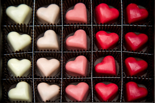 Delicious heart-shaped chocolate  pralines on a black background image.