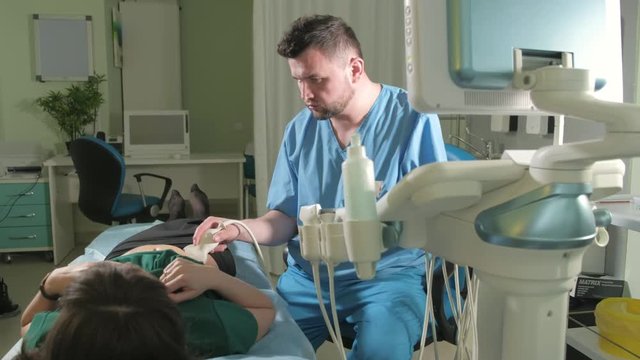 Doctor doing 3d ultrasound on belly of t woman in clinic 4k