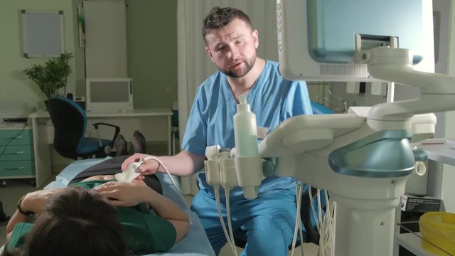 Doctor doing 3d ultrasound on belly of t woman in clinic 4k