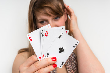 Beautiful girl hides behind poker cards