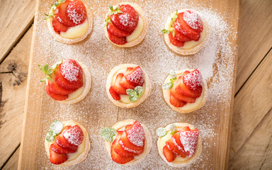 mini strawberry tarts on wood background