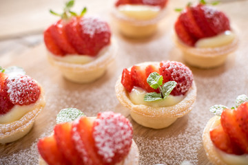 mini strawberry tarts on wood background