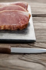 Sirloin chop on black slate plate with knife