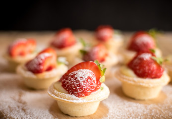 mini strawberry tarts on wood background